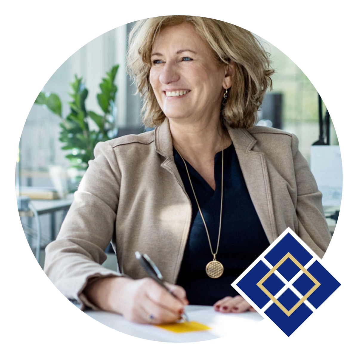 Sibylle Grüßer, eine Frau in einem beigen Blazer sitzt an einem Schreibtisch, lächelt und schreibt etwas auf ein Blatt Papier. In der rechten unteren Ecke des Bildes ist ein geometrisches Logo in Blau und Gold zu sehen. Dieses Logo zeigt das von ihr entwickelte Kompetenzmodell, dass auf dieser Website vorgestellt wird.